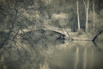 Old bridge in park, vintage toned.