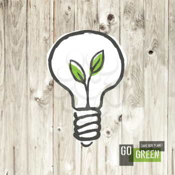 Green eco energy concept, plant growing inside the light bulb, on wooden texture.