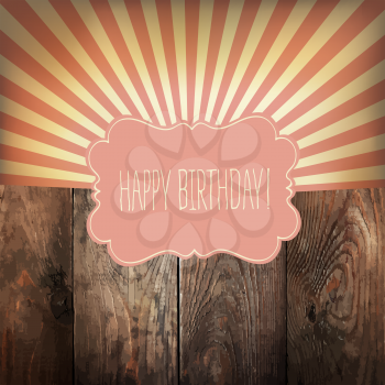 Happy Birthday greeting card with sunrays and vintage label. On wooden background