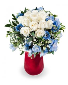 colorful floral bouquet from white roses and delphinium centerpiece in red vase isolated on white background