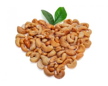 Cashew nuts in the form of heart with leaves isolated on white background