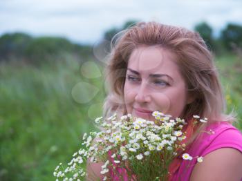 Portrait of young woman with bouquet of daisies.