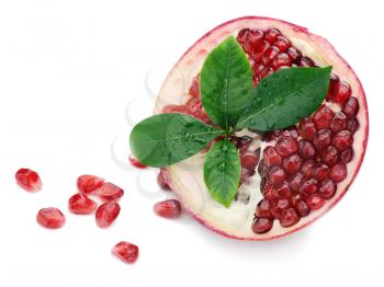 Pomegranate fruit with green leaves isolated on white background.