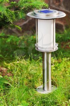 Solar-powered lamp on garden background. Selective focus.