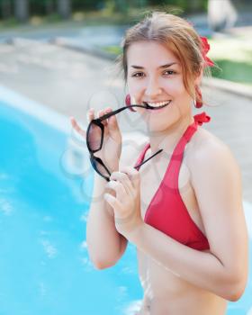 Young beautiful smiling girl near swimming pool. Closeup.