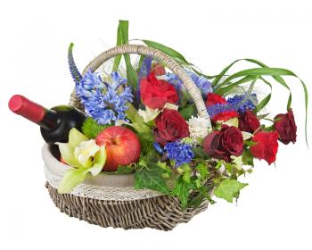 Flower arrangement of roses, orchids, fruits and bottle of wine isolated on white background.
