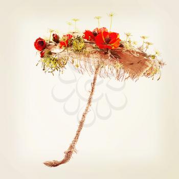 Decorative umbrella from burlap, mats and artificial flowers with retro filter effect.