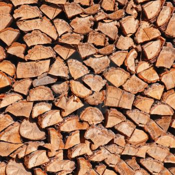 Dry chopped firewood logs in pile. Nature background. 