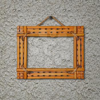 Bamboo frame on gray stucco concrete wall. Closeup.