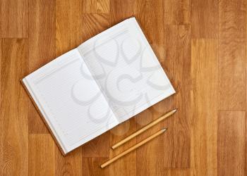 Blank notepad with office supplies on wooden table. Above view.