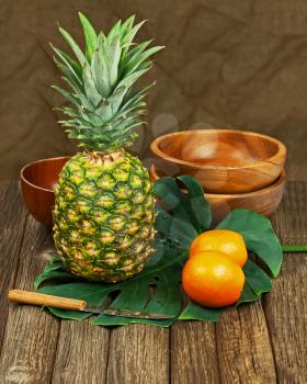 Still Life with Pineapple and Oranges on Wooden background. Closeup.