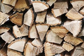 Dry chopped firewood logs in pile. Nature background.