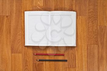 Blank notepad with office supplies on wooden table. Above view.