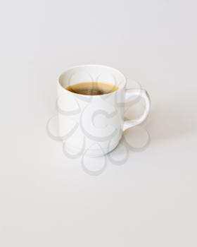White Cup of Hot Coffee on Gray Background. Side View of Top.