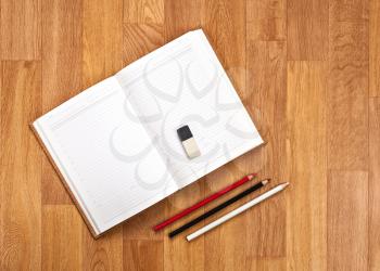 Blank Notepad with Office Supplies on Wooden Table. Above Wiew.