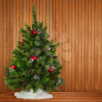 Green Decorated Christmas Tree on Wooden Background. Closeup.