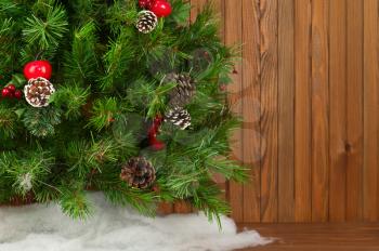 Fragment of Green Decorated Christmas Tree on Wooden Background. Closeup.