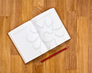Blank notepad with office supplies on wooden table.