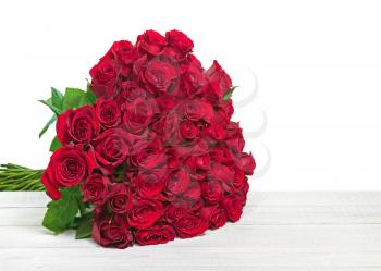 Colorful flower bouquet from red roses isolated on wooden background. Closeup.