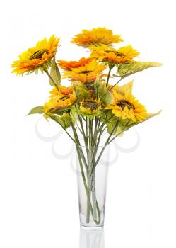 Composition from bright artificial sunflowers in glass vase isolated on white background. Closeup.