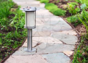 Solar-powered lamp on garden path. Nature background. Selective focus.