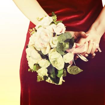Beautiful wedding bouquet from white and pink roses in hands of bride with retro filter effect.