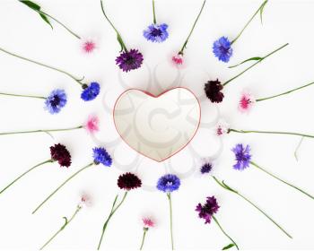 Gift in shape of heart with pattern from petals of flowers on white background. Overhead view. Flat lay.