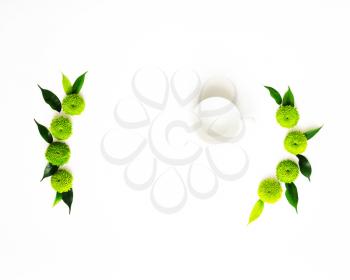 Cup for coffee or tea with decoration of chrysanthemum flowers and ficus leaves isolated on white background. Overhead view. Flat lay.
