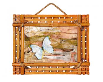 Bamboo photo frame with abstract composition of butterflies, birch bark and straw isolated on white background.