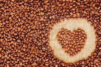 Heart coffee frame made of coffee beans on burlap texture. 
