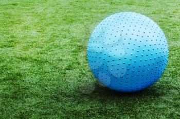 Blue ball on green grass background. Closeup. 