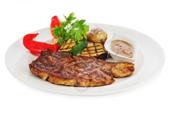 Grilled steaks, baked potatoes and vegetables on white plate isolated on white background.