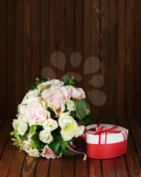 Beautiful wedding bouquet from white and pink roses on wooden background.