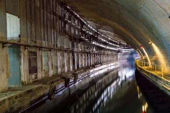 Illuminated Underground Tunnel with Water for passage and repair submarines.