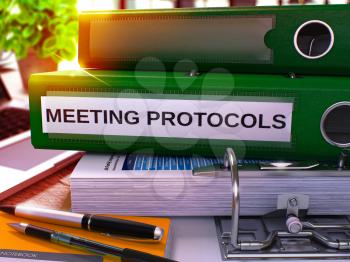 Meeting Protocols - Green Ring Binder on Office Desktop with Office Supplies and Modern Laptop. Meeting Protocols Business Concept on Blurred Background. 3D Render.