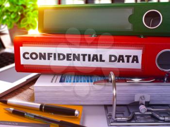 Confidential Data - Red Office Folder on Background of Working Table with Stationery and Laptop. Confidential Data Business Concept on Blurred Background. Confidential Data Toned Image. 3D.