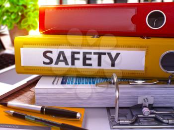 Yellow Office Folder with Inscription Safety on Office Desktop with Office Supplies and Modern Laptop. Safety Business Concept on Blurred Background. Safety - Toned Image. 3D.