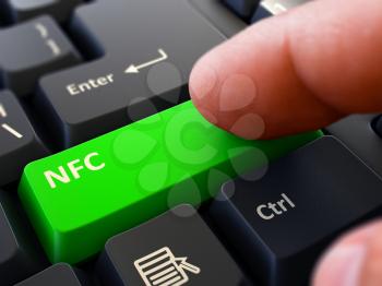 NFC -  Near Field Communication - Button. Male Finger Clicks on Green Button on Black Keyboard. Closeup View. Blurred Background. 3D Render.
