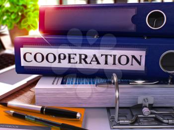 Blue Office Folder with Inscription Cooperation on Office Desktop with Office Supplies and Modern Laptop. Cooperation Business Concept on Blurred Background. Cooperation - Toned Image. 3D.
