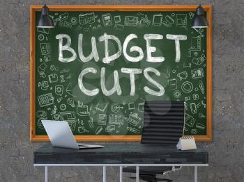 Hand Drawn Budget Cuts on Green Chalkboard. Modern Office Interior. Dark Old Concrete Wall Background. Business Concept with Doodle Style Elements. 3D.