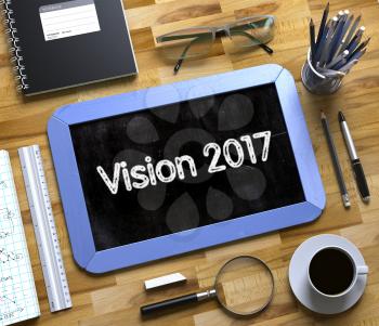 Vision 2017 on Small Chalkboard. Vision 2017 Handwritten on Blue Chalkboard. Top View Composition with Small Chalkboard on Working Table with Office Supplies Around. 3d Rendering.