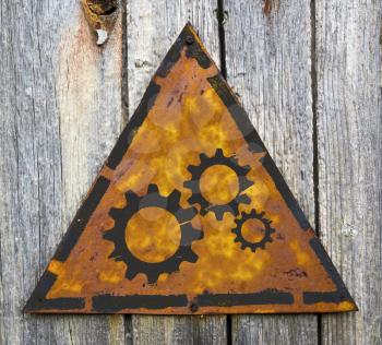 Royalty Free Photo of Cogs on a Sign Against a Wall