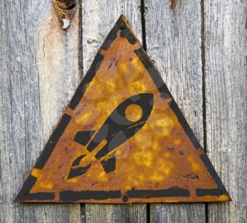 Royalty Free Photo of a Rocket on a Weathered Sign Against a Wooden Wall