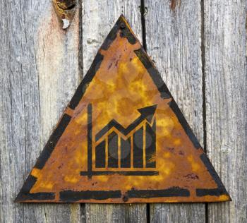 Royalty Free Photo of a Growth Chart on a Rusty Sign Against a Wooden Wall