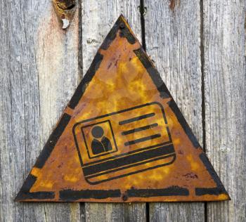 Royalty Free Photo of an ID on a Rusty Sign Against a Wooden Wall
