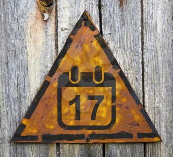 Royalty Free Photo of a Calendar Date on a Rusty Sign Against a Wooden Wall