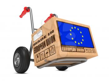 Cardboard Box with Flag of European Union and Made in European Union Slogan on Hand Truck White Background. Free Shipping Concept.