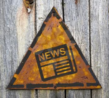 Royalty Free Photo of a Weathered Newspaper Sign on Wood