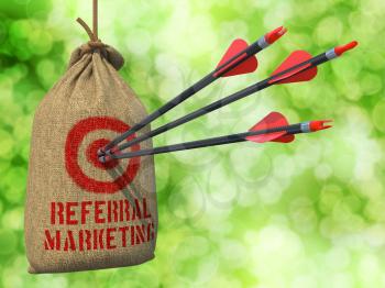 Referral Marketing - Three Arrows Hit in Red Target on a Hanging Sack on Green Bokeh.