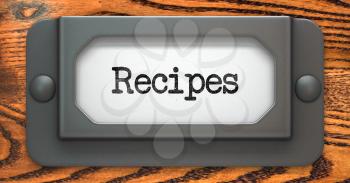 Recipes - Inscription on File Drawer Label on a Wooden Background.